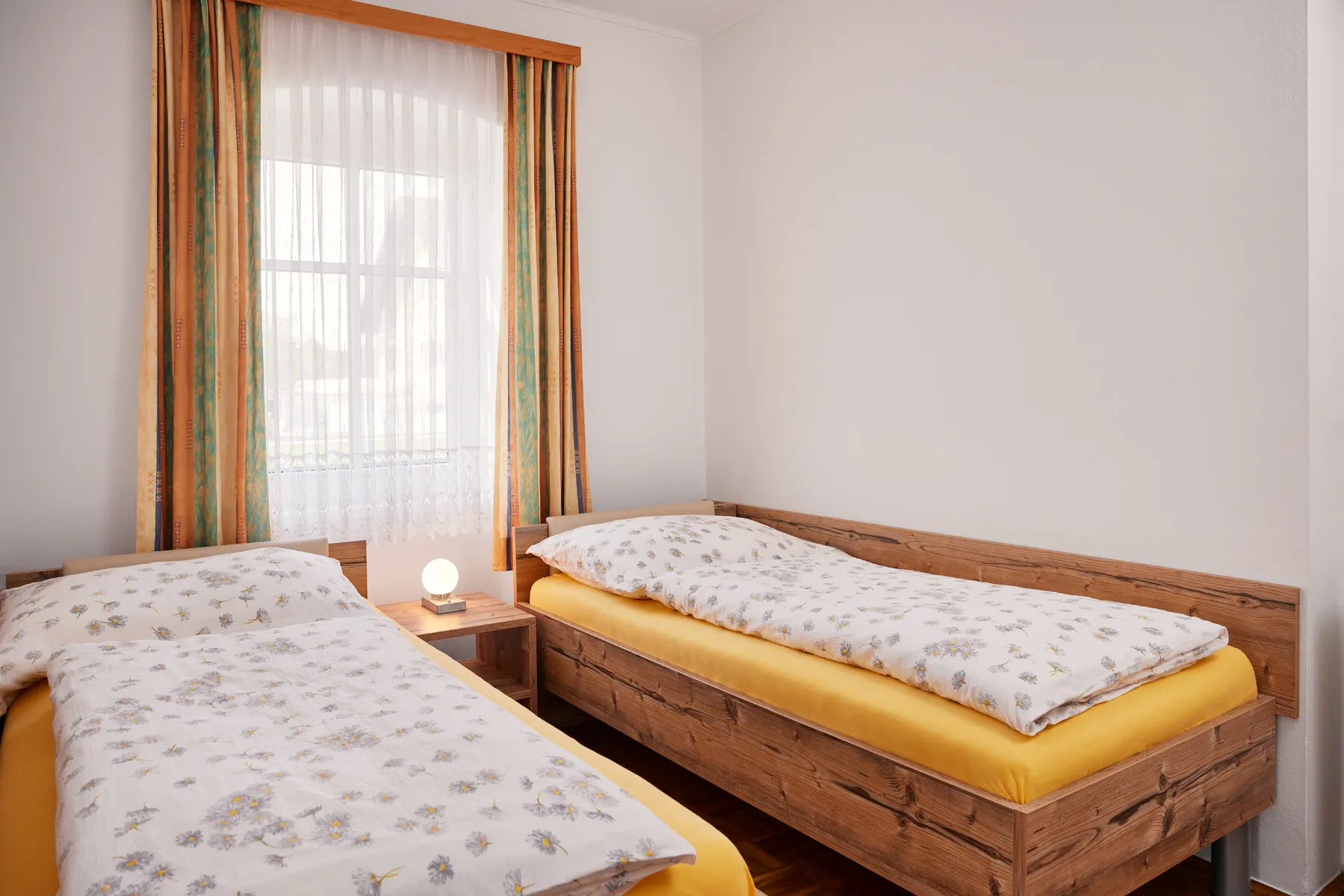 Schlafzimmer der Ferienwohnung Eins mit zwei Einzelbetten aus Holz